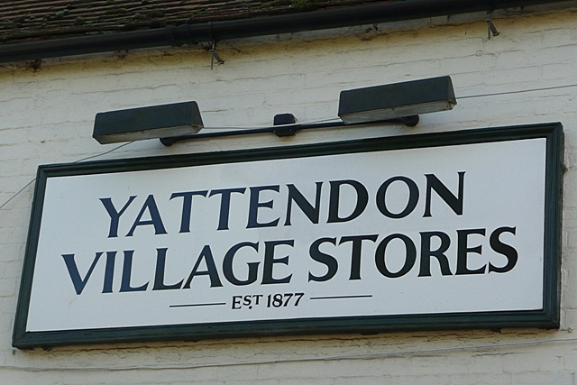 Black and white signboard with Yattendon Village Stores in serif typeface